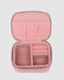 Pink jewelry case with compartments on a light gray background